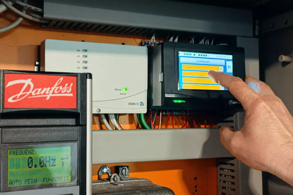 Regelungstechnik. Finger tippt auf ein Display einer Regelungstechnik