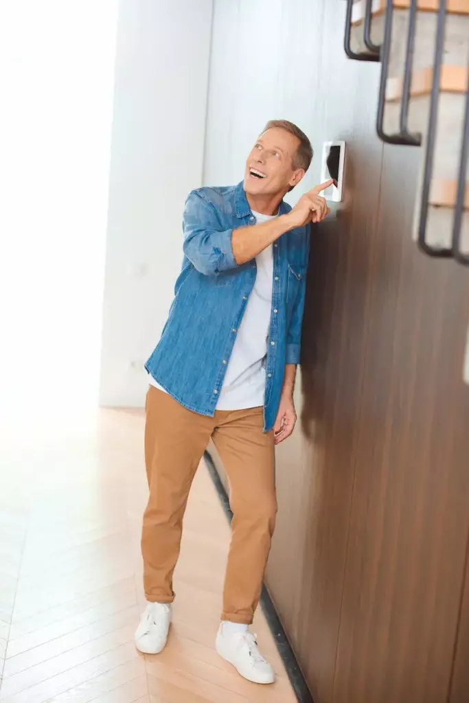 Ein Mann drückt begeistert auf seiner Smart Home Steuerung